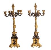A pair of French patinated and parcel gilt bronze six light candleabra, in Neoclassical style,