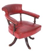 A Victorian studded red leather upholstered swivel elbow chair,