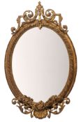 A Victorian gilt composition framed oval wall mirror in Rococo revival style,
