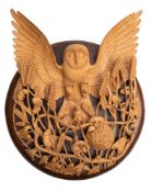 A carved beechwood and oak mounted openwork wall relief modelled as an owl descending on harvest