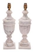 A pair of white and black veined marble table lamps modelled as urns,