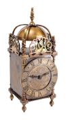 An Edwardian brass lantern clock having an eight-day duration French timepiece movement with a