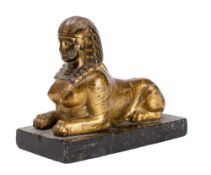 A French or British gilt and lacquered metal figural desk weight modelled as a recumbent sphinx,