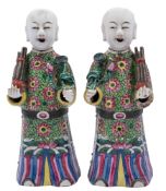 A pair of Chinese porcelain figures, each wearing elaborate famille rose decorated robes,