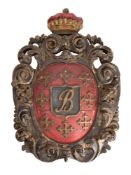 A carved wood and polychrome decorated coat-of-arms with central initial B within a shield enclosed