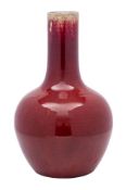 A Chinese flambé bottle vase the rich ox-blood glaze turning darker at the neck and falling short