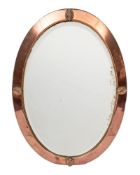 A copper framed oval wall mirror in Arts & Crafts taste,