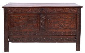 A Charles II carved oak coffer, circa 1670; with hinged cover, above an abundantly carved front,