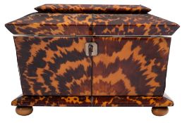 WITHDRAWN A George IV tortoiseshell tea caddy of sarcophagus form with two lidded compartments,