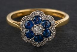 An 18ct gold, round, mixed-cut sapphire and round, brilliant-cut diamond cluster ring,