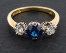 An 18ct gold, round, brilliant-cut diamond and round, mixed-cut sapphire, three-stone ring,