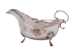A George VI silver sauceboat, Birmingham 1937 with a wavy edge and scroll handle,