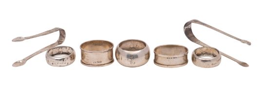 Five silver serviette rings (various dates and makers), a pair of George III silver sugar tongs,