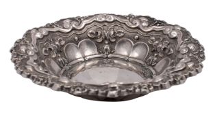 A French silver circular dish with embossed scroll, fluted husk and ribbon decoration,