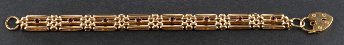 A 1970's, 9ct gold, garnet set, gate-link bracelet with heart-shaped clasp,