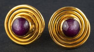 A pair of round, cabochon-cut star ruby ear studs, total estimated ruby weight ca.