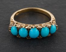 An oval, cabochon-cut turquoise, five-stone ring, with rose-cut diamond spacers and pierced gallery,