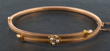 A late 19th/ early 20th century, seed pearl hinged bangle, with clover frontispiece, stamped '15',