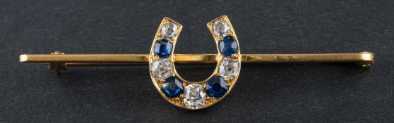 A mixed-cut sapphire and cushion-cut diamond horseshoe brooch, total estimated diamond weight ca. 0.