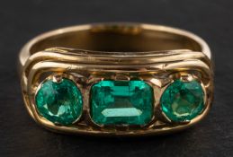 A round, mixed-cut and emerald-cut emerald three-stone ring, total estimated emerald weight ca. 1.