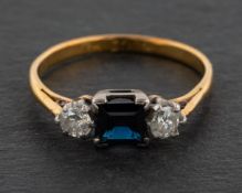 A round, brilliant-cut diamond and step-cut sapphire, three-stone ring,