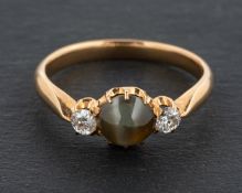 A round, cabochon-cut, chatoyant chrysoberyl and round, brilliant-cut diamond three-stone ring,
