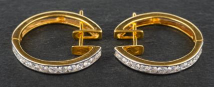 A pair of round, brilliant-cut diamond, hoop earrings, total estimated diamond weight ca. 0.