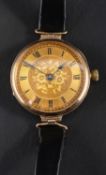 A 9ct gold wristwatch, the gilded dial with Roman numerals on engraved floral background,