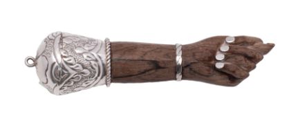 An Indian silver mounted and carved wood pendant forearm the hand with thumb between the index and