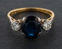 An oval, mixed-cut sapphire and round, brilliant-cut diamond, three-stone ring,