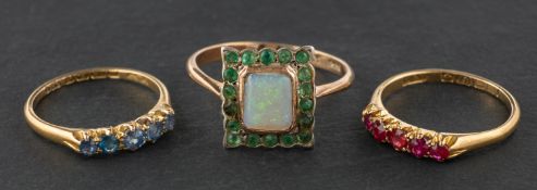 Three gemset rings, including a square, opal and emerald cluster ring,