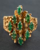 A navette-shaped, emerald cluster ring, with a bark-like textured surface,