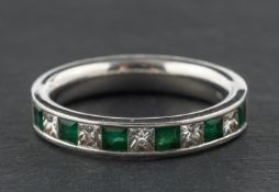 A platinum, princess-cut diamond and step-cut emerald half eternity ring, total diamond weight 0.
