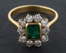 An 18ct gold, emerald-cut emerald and round, brilliant-cut diamond cluster ring,