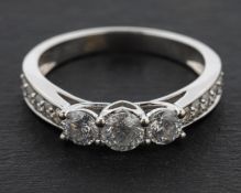 An 18ct gold, round, brilliant-cut diamond three-stone ring,