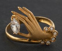 A hand-shaped ring, set with CZ, stamped '750', length of ring head ca. 1.