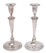 A pair of plated candlesticks with circular fluted sconces,