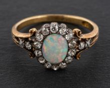 An oval, cabochon-cut opal and single-cut diamond cluster ring, estimated opal weight ca. 0.