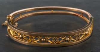 An Edwardian, 9ct gold, hinged bangle, with urn-shaped decoration, with hallmarks for Birmingham,