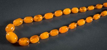 A graduated, amber bead necklace, composed of sixty oblong beads,