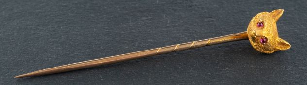 A late 19th/ early 20th century fox mask tie-pin, with cabochon-cut, ruby eyes, stamped '18CT',