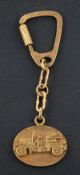 An oval keyring with applied decoration depicting a classic car,
