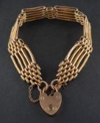 A gate-link bracelet with heart-shaped clasp, stamped '9CT', total length ca.