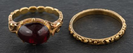 Two rings with decorative engraving, one with a foil backed, probably quartz, cabochon-cut stone,