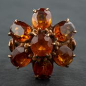 An oval and round, mixed-cut citrine cocktail ring, of flowerhead design, stamped '9CT',