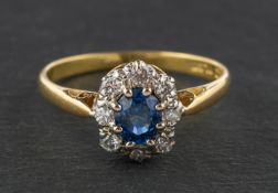 An oval, mixed-cut sapphire and diamond cluster ring, estimated sapphire weight ca. 0.