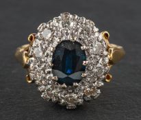 An oval, mixed-cut sapphire and round, brilliant-cut diamond cluster ring,