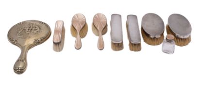 A George V silver and beige enamel mounted four-piece dressing table set,