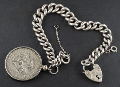 A graduated, curb-link bracelet with a heart-shaped clasp, and a mounted half dollar coin,