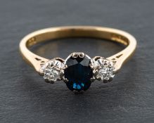 An 18ct gold, oval, mixed-cut sapphire and round, brilliant-cut diamond, three-stone ring,